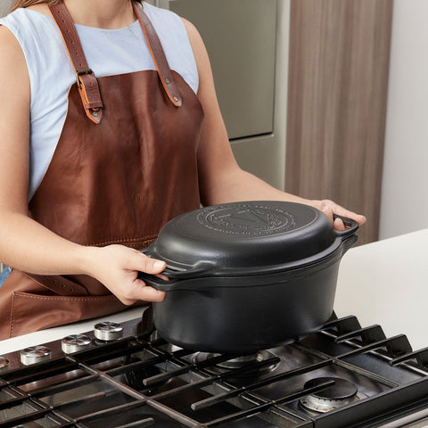 Persona colocando olla ovalada Victoria con tapa sobre la estufa