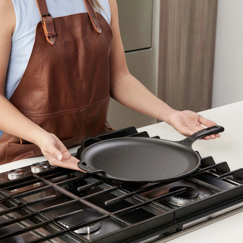 Persona mostrando comal de 30 cm Victoria con mango y asa auxiliar