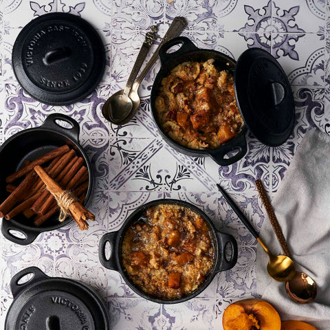 Mini ollas cocotte Victoria con postres de cubierta desmoronada, junto a canela y fruta