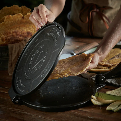 Persona retirando plátano aplanado de la tortilladora de 25 cm Victoria