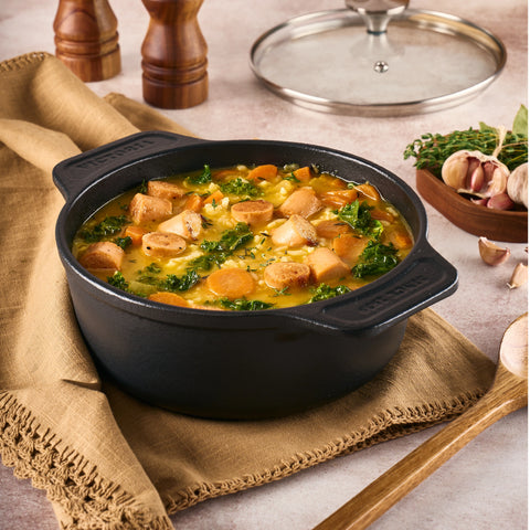Olla de 1.9 L Victoria destapada con sopa, verduras y salchichas, sobre servilleta
