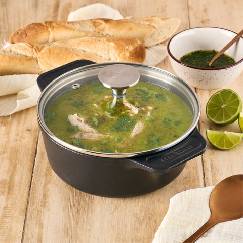 Olla de 1.9 L Victoria con sopa verde bajo tapa de vidrio, junto a pan