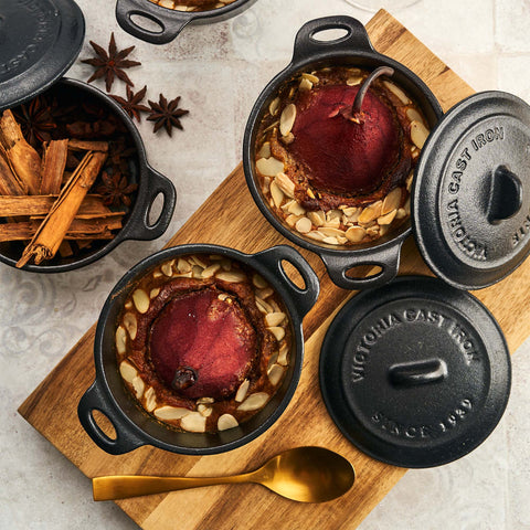 Mini ollas cocotte Victoria con peras rojas y almendras, junto a canela