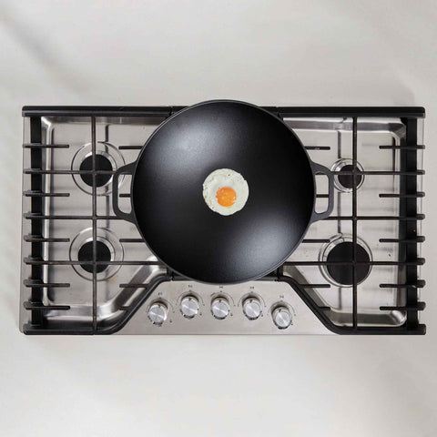 Wok Victoria con un huevo estrellado al centro sobre la estufa