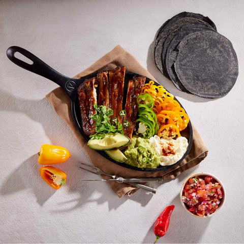 Sartén fajita Victoria con carne, pimientos, guacamole y tortillas azules al lado