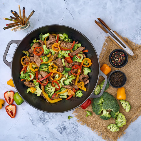 Vista superior de wok Victoria con carne y verduras junto a palillos