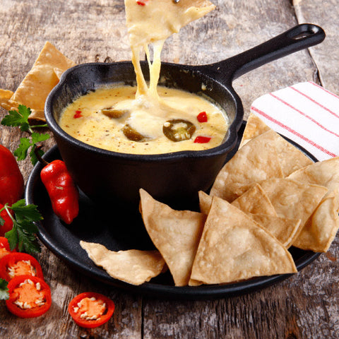 Sartén salsero Victoria con queso fundido y chiles, rodeado de totopos